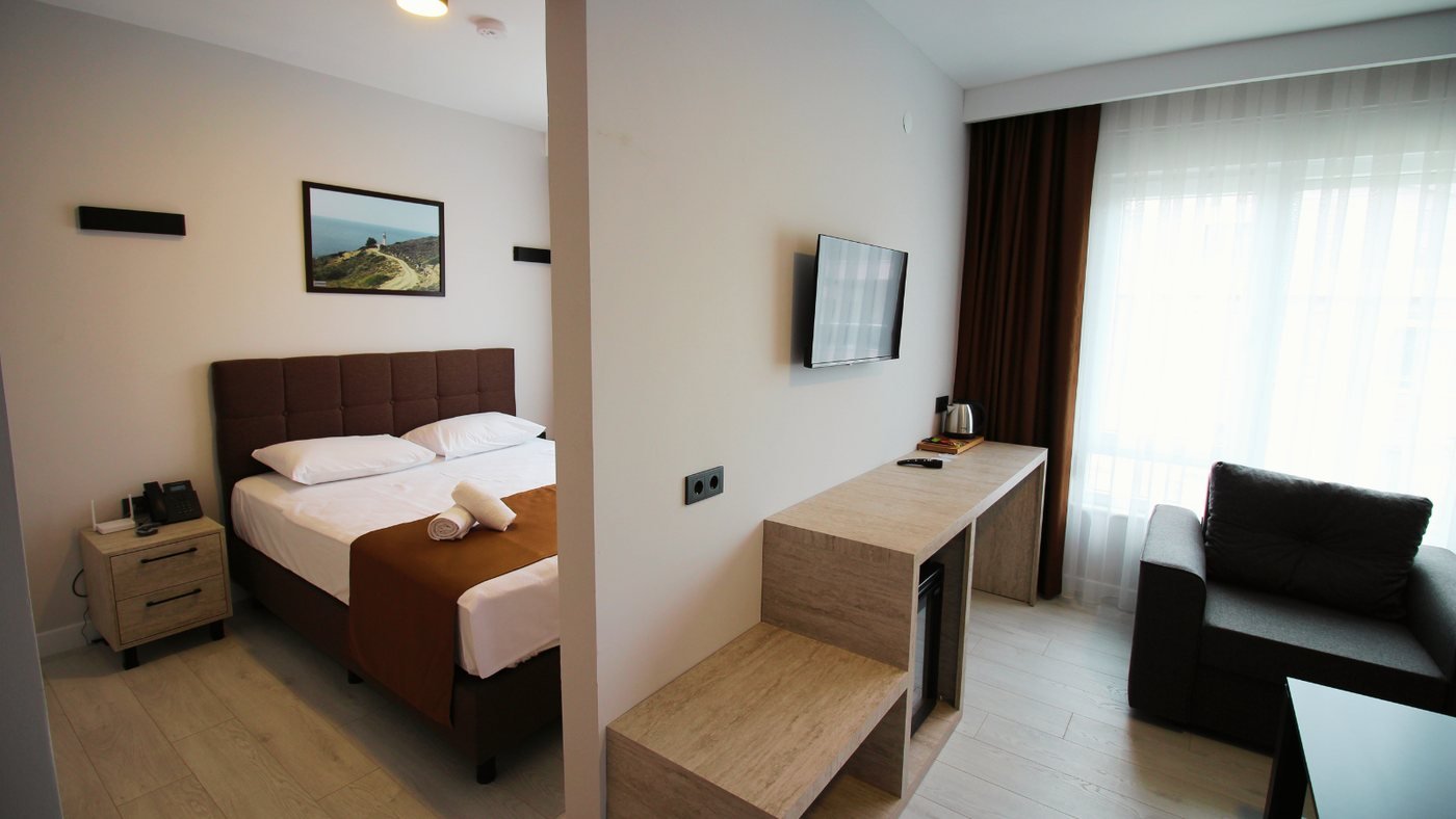 Altınay Hotel Aile Odası — çift yatak, oturma alanı ve çalışma masası
