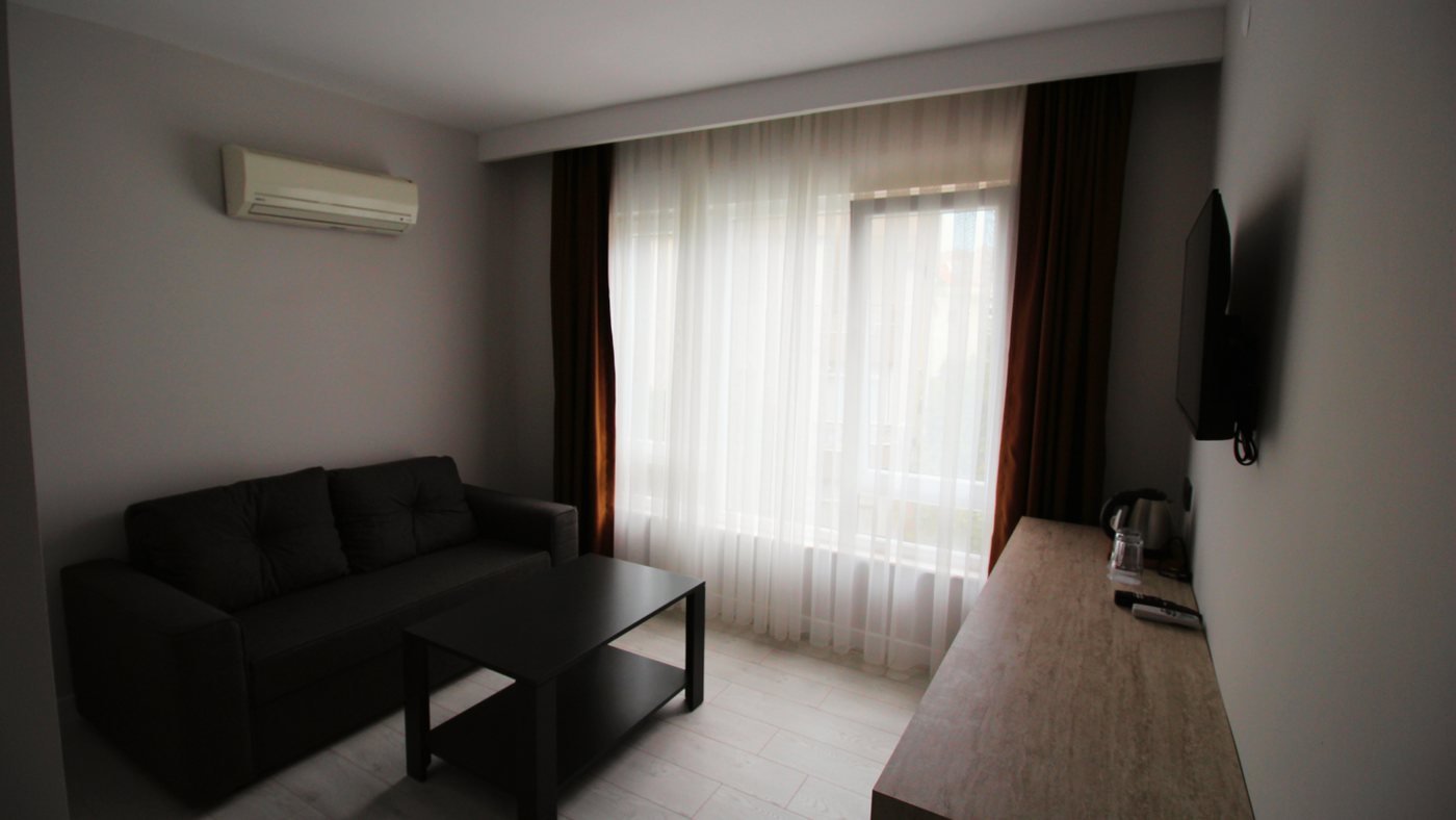 Altınay Hotel Suit Oda — ayrı oturma alanı ve geniş pencere
