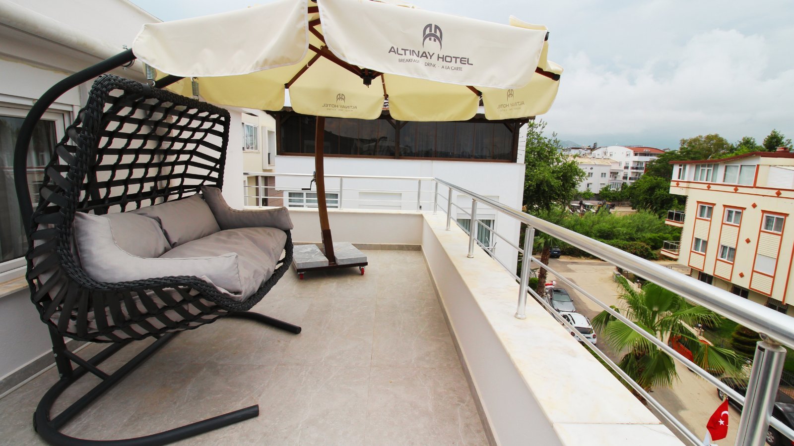 Altınay Hotel teras salıncaklı koltuk ve şehir manzarası